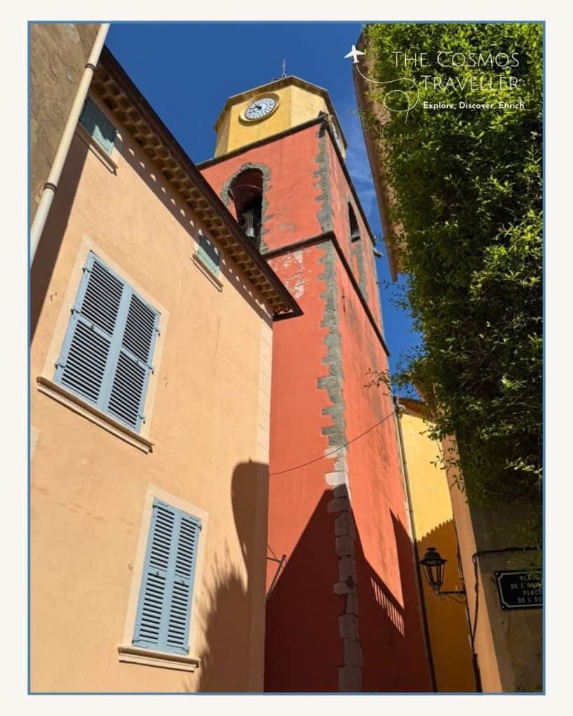 The bell tower of Église Notre-Dame de l’Assomption in Saint-Tropez, seen from street level.