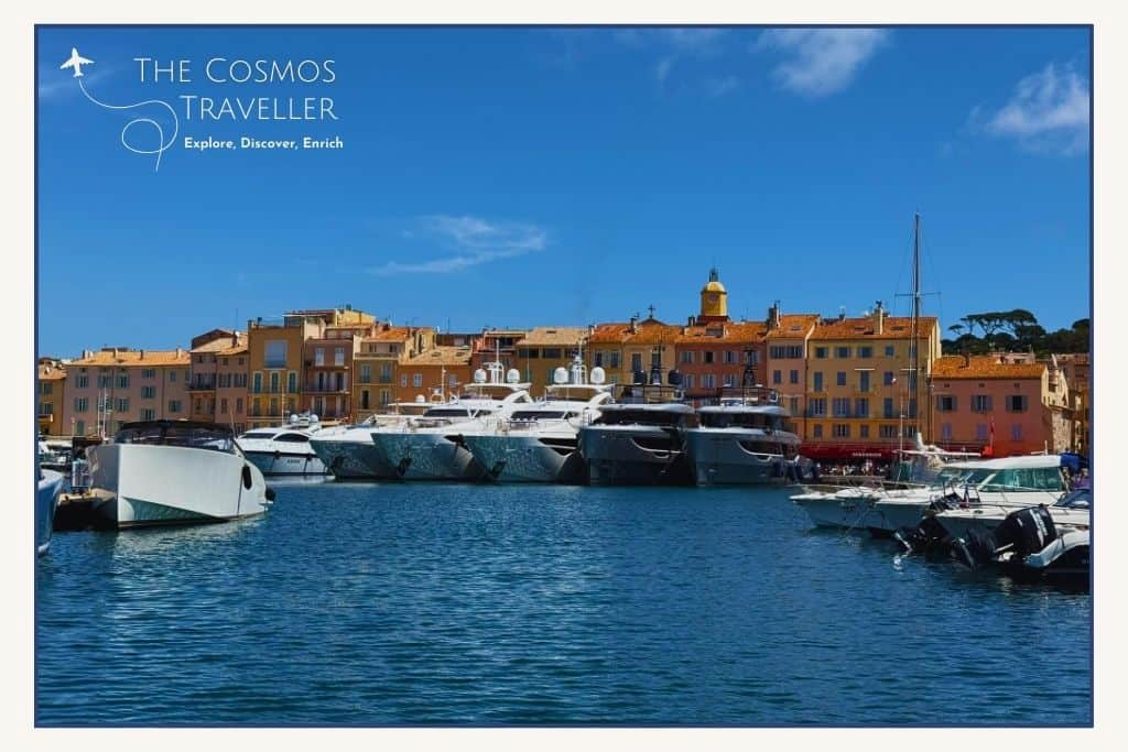 Several superyachts dock in the Saint-Tropez harbour, contrasting with the town’s small colourful fishermen’s houses.
