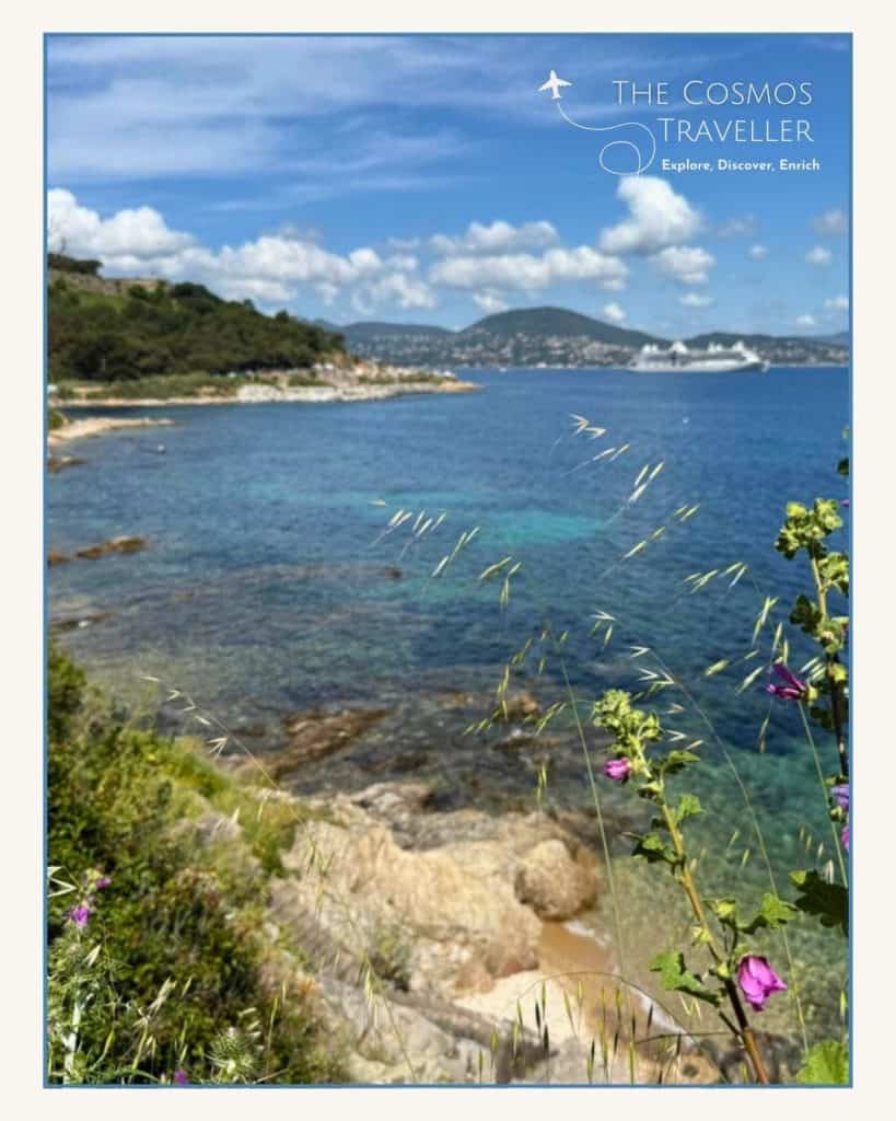 The coastline of the Sentier du Littoral with a large cruise ship visible in the Gulf of Saint-Tropez.