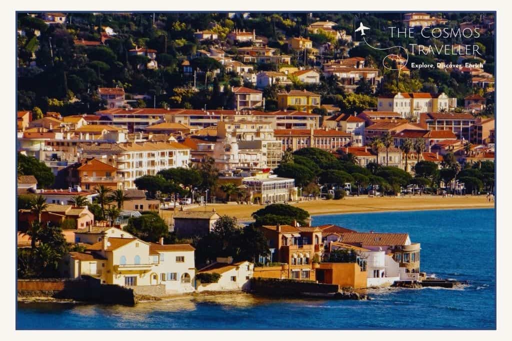 Sainte Maxime coastline on the Gulf of Saint-Tropez, with calm waters, sandy beach, and a tree-lined promenade.