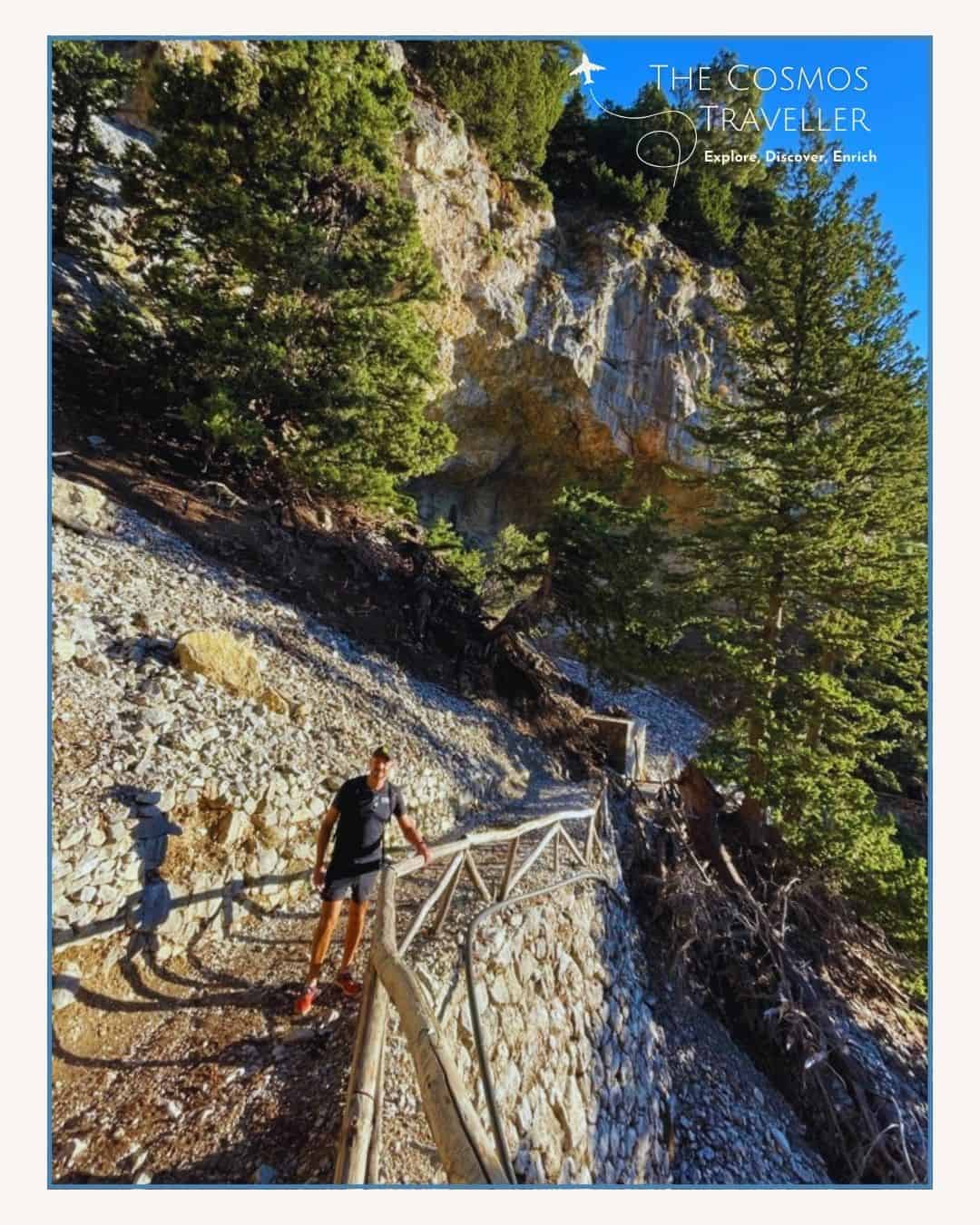 Trees, cliffs, and handrails along the steep descent at the start of the Samaria Gorge hike.