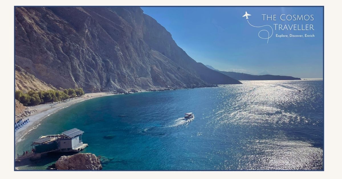 Hidden beach in Crete with boat on blue water, framed by cliffs — one of Crete’s best secluded coastal spots.