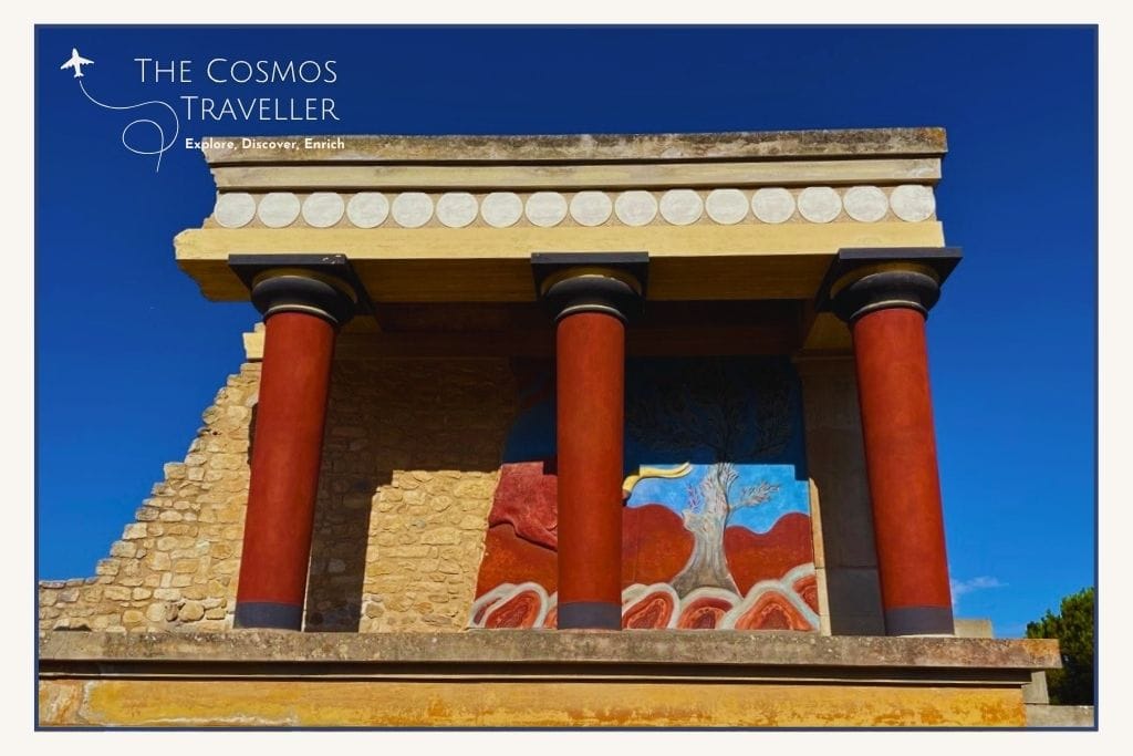 The three iconic red pillars at Knossos Palace in Crete, part of the restored ruins of the ancient Minoan civilization.