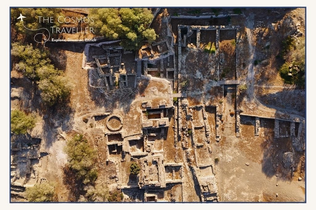Aerial drone photo of Minoan ruins at Kommos Beach in Crete, surrounded by sand, paths, and low Mediterranean shrubs.