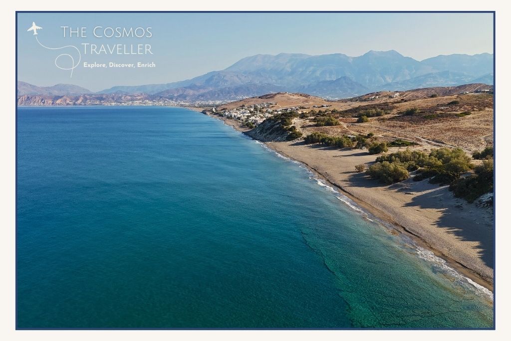 Drone view of Sarantari Beach, one of Crete’s hidden gems; blue water, sandy coast, and wild dunes behind.