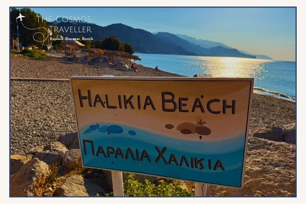 In-town pebble beach Halikia in Paleochora, Crete, with clear blue water and tavernas across the street.