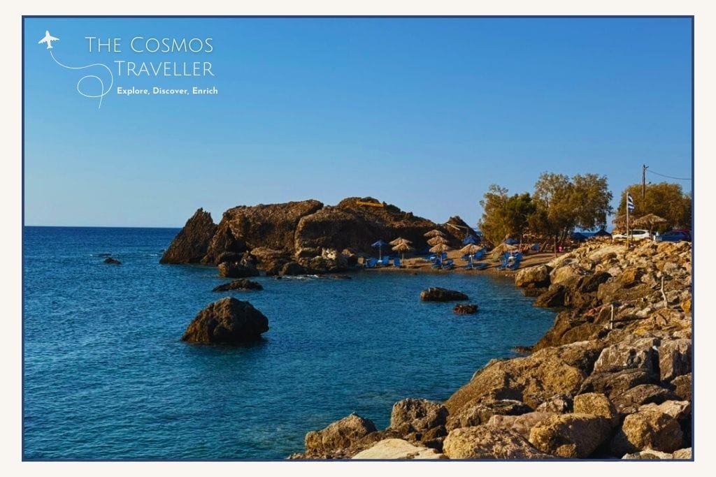 Tiny pebble cove at Methexis Beach, Paleochora, Crete, with sunbeds and a traditional taverna nearby.
