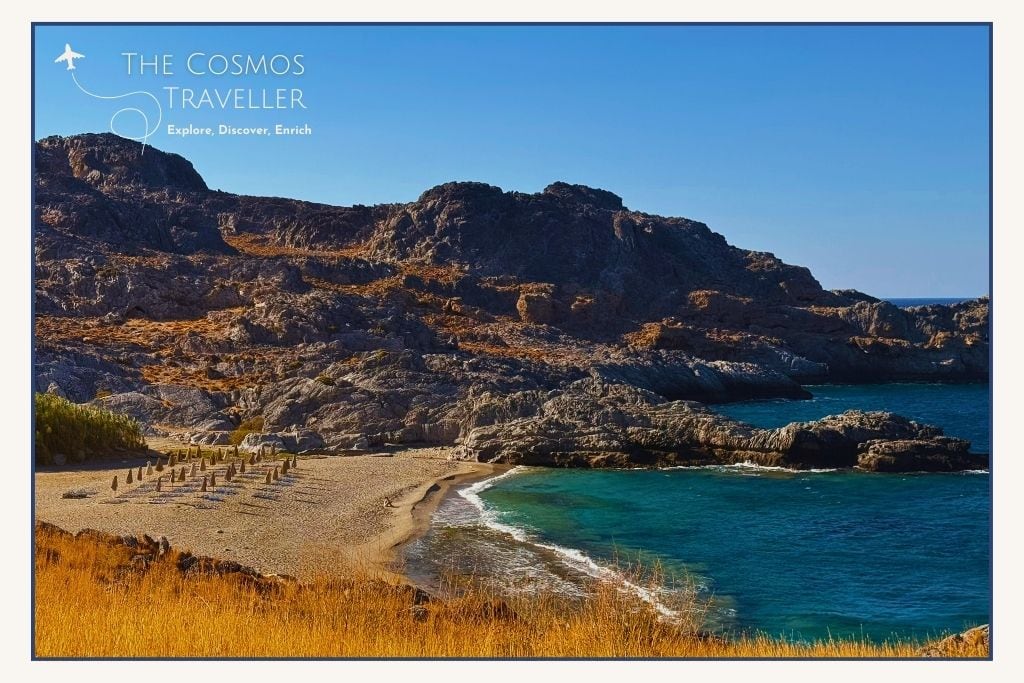 View of Ammoudi Beach from the road above, showing its pebbly shoreline and surrounding hills near Plakias.
