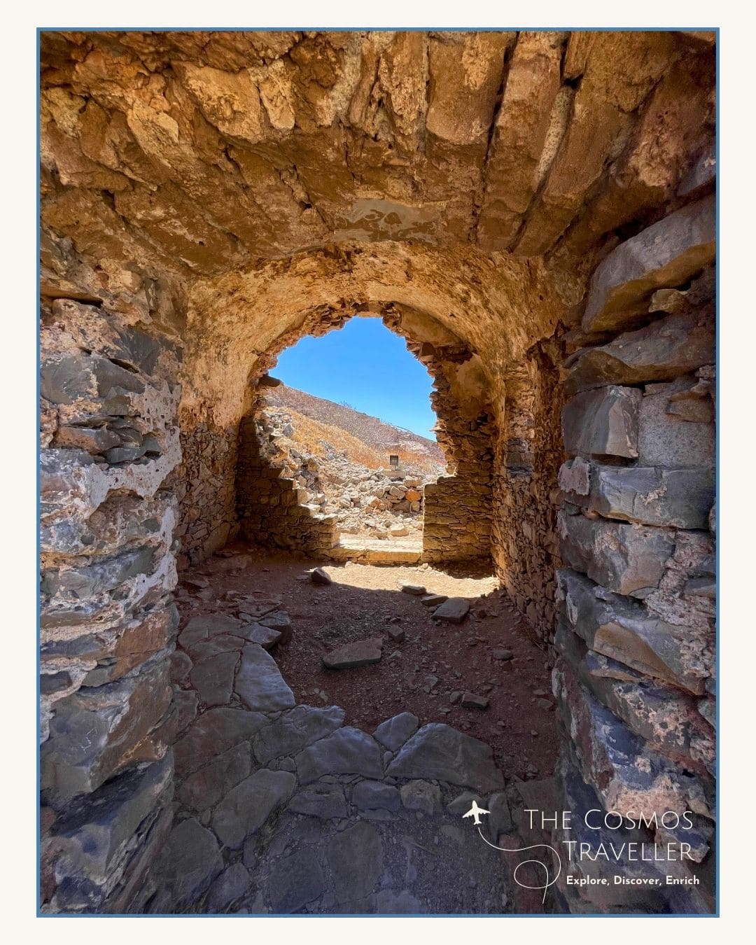 Interior of a ruined Spinalonga home with stone walls and arched ceiling