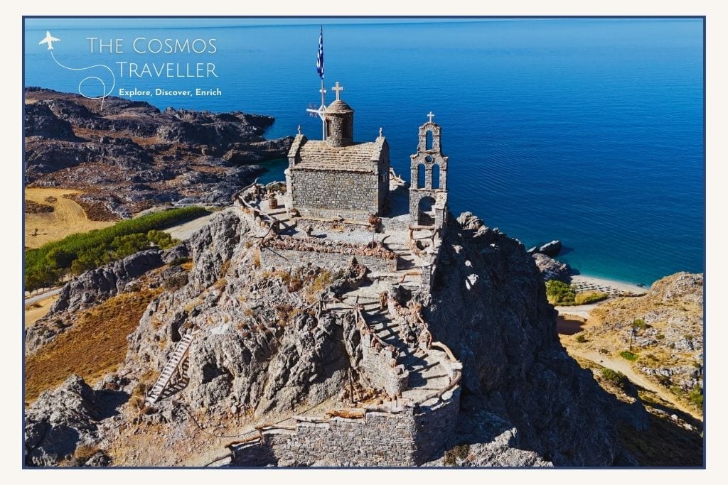 Drone shot of the small church on a rocky peak above Ammoudaki Beach, with the Libyan Sea in the background near Plakias.