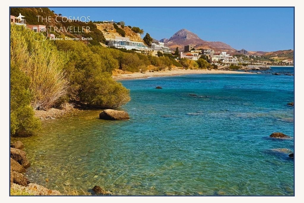 Distant view of Skinos Beach west of Plakias, a quiet pebbly cove with calm blue waters.