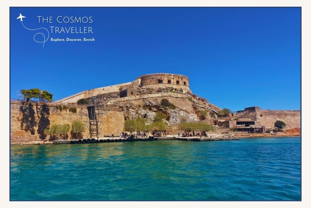 Boat view of Spinalonga Island’s Venetian fortress rising above the blue Cretan waters