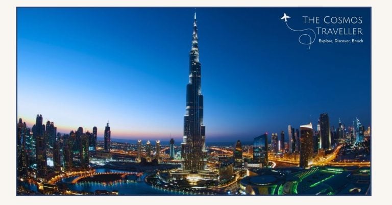 Twilight view of Downtown Dubai at night with the Burj Khalifa and Dubai Fountain lights reflecting across the city.