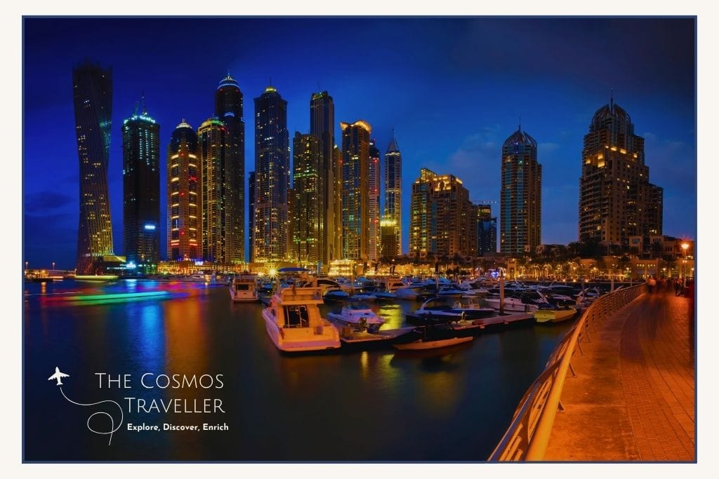 Dubai Marina skyline reflected in the water with yachts and twinkling towers after dark.