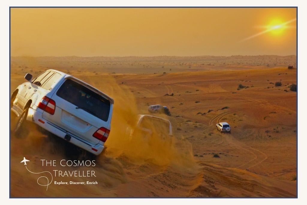 4x4 Land Cruiser kicking up sand at sunset during a desert safari across the red Lahbab dunes.