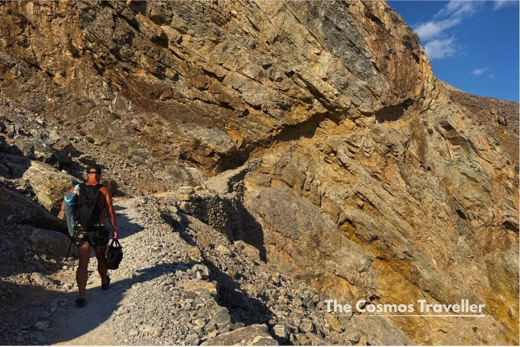 Hiking the rocky cliff path away from Glyka Nera beach, Crete.