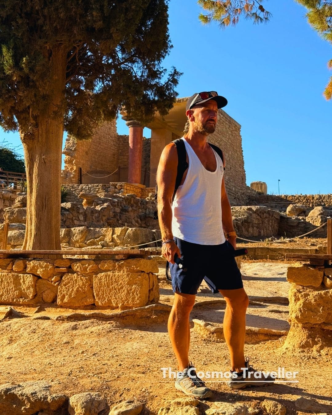 A visitor exploring the Knossos ruins in soft evening light